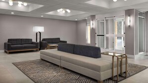 A modern living room with a sectional sofa, two armchairs, a coffee table, and a patterned rug.