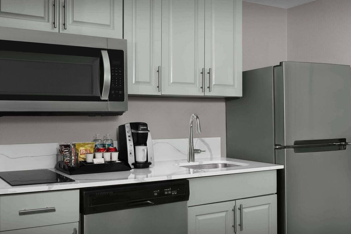 A kitchen with a microwave, coffee maker, and dishwasher.