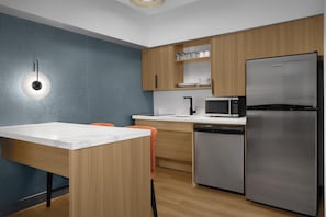 A modern kitchen with wooden cabinets, a stainless steel refrigerator, a microwave, and a dishwasher. - Homewood Suites by Hilton Ft. Worth-North at Fossil Creek (Fort Worth)