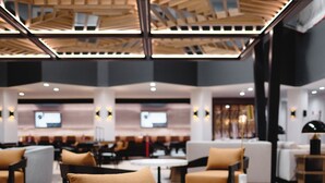 A modern interior with seating areas, a high ceiling, and visible structural elements.
