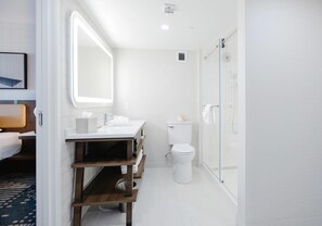 A modern bathroom with a shower, toilet, and vanity.