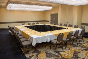 Conference room with a long table, chairs, and a chandelier.