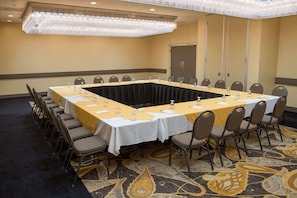 Conference room with a long table, chairs, and a chandelier.