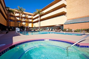 Relax by the pool surrounded by lounge chairs and umbrellas.