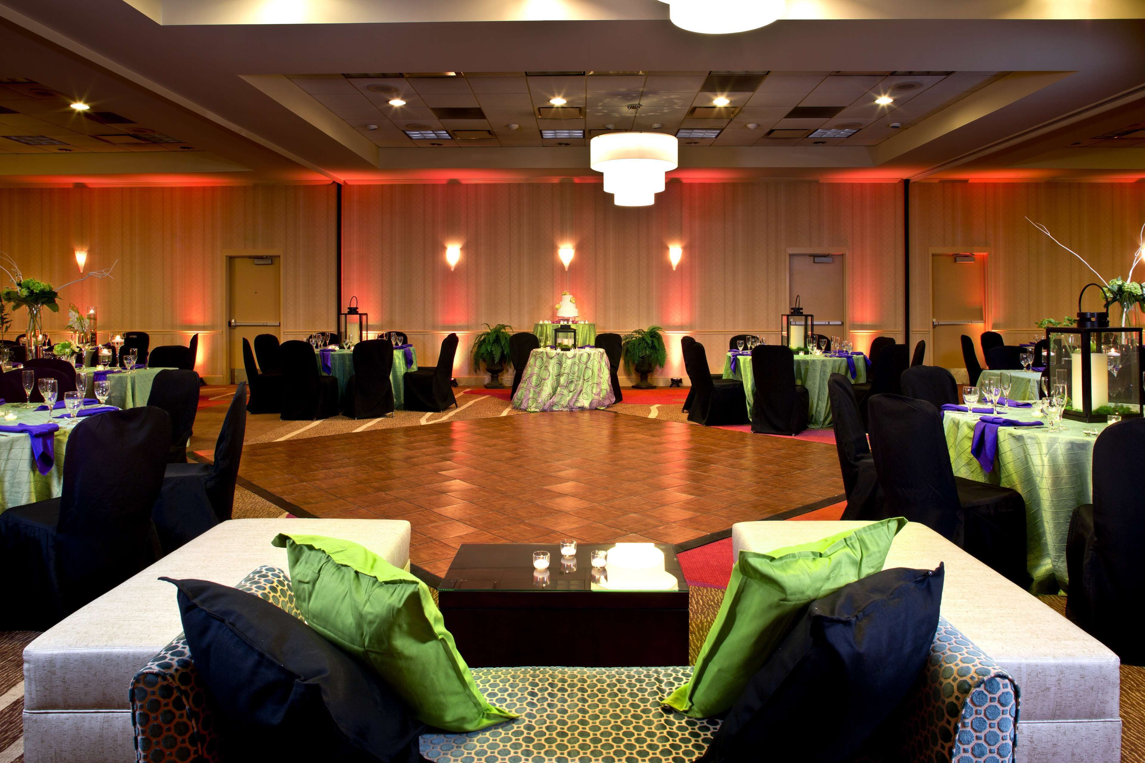 A banquet hall with round tables, chairs, and a dance floor.