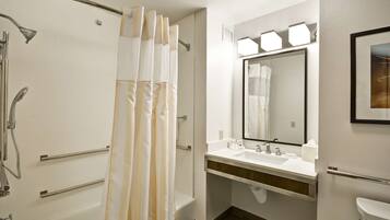 A modern bathroom with a shower, toilet, sink, and mirror.