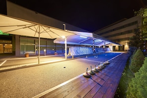 Enjoy a relaxing evening in our outdoor seating area with comfortable chairs and a shaded spot under a large umbrella.