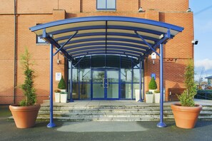 A building entrance with a covered walkway, steps, and potted plants. - Holiday Inn Express Birmingham - Castle Bromwich by IHG (Birmingham)