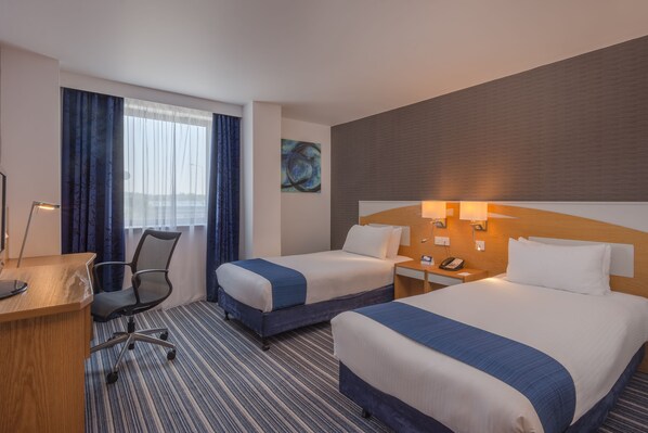 A hotel room with two beds, a desk, a chair, and a large window with curtains. - Holiday Inn Express Birmingham - Castle Bromwich by IHG (Birmingham)
