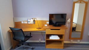 A hotel room with a wooden desk, a black office chair, a flat-screen TV, a telephone, and a mirror. - Holiday Inn Express Birmingham - Castle Bromwich by IHG (Birmingham)