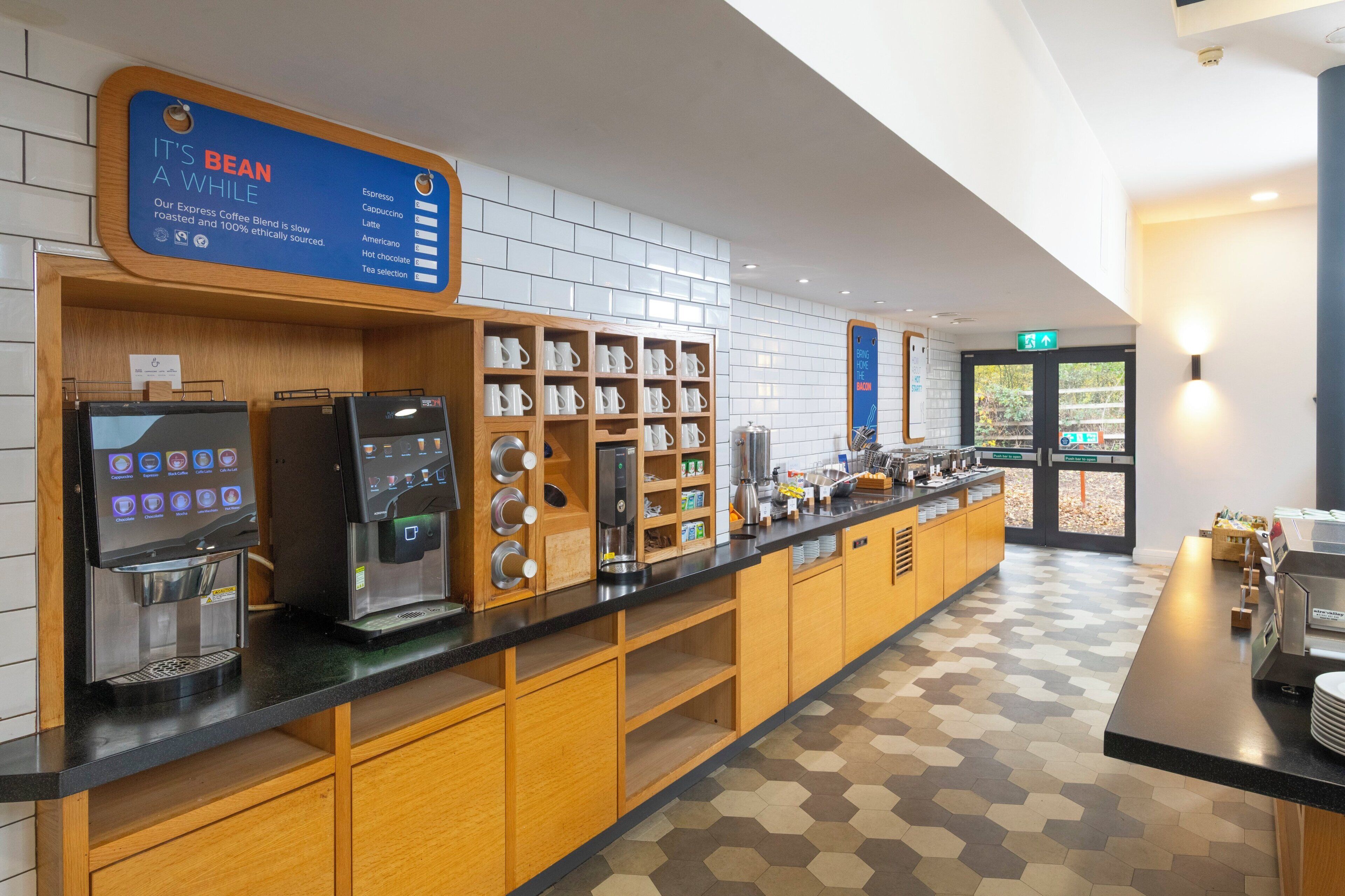 Una estación de café con máquinas de espresso, una barra de café y una variedad de granos de café exhibidos en estantes.