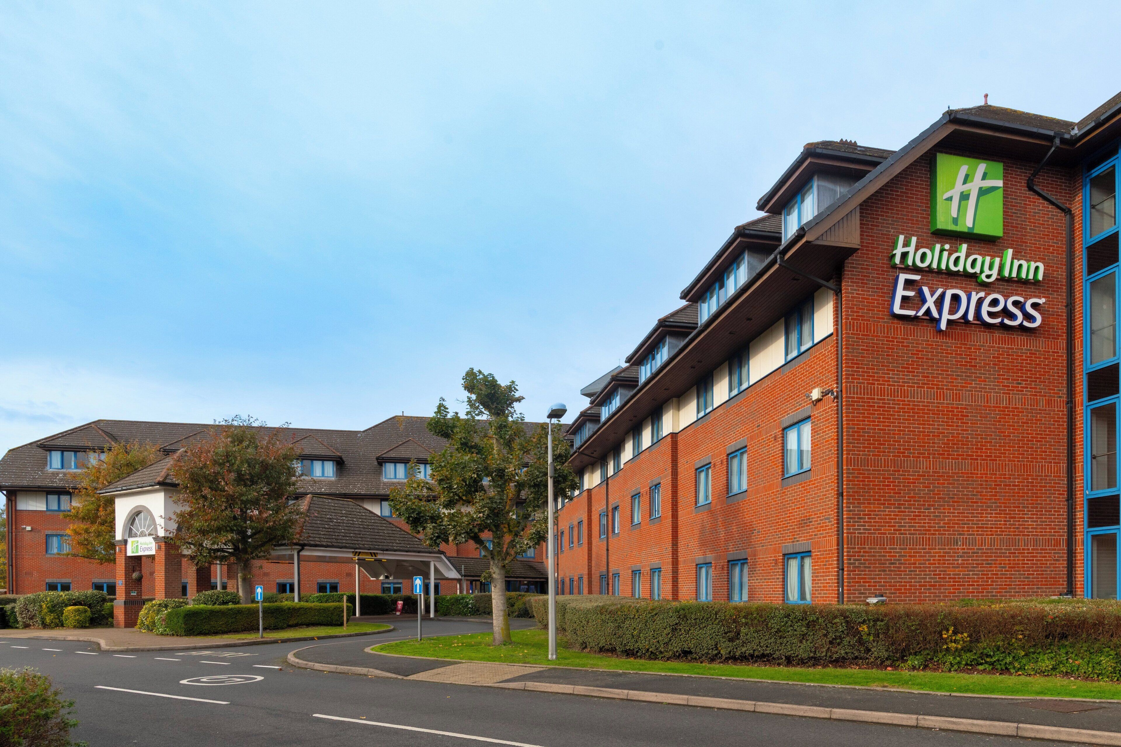 Un bâtiment de la chaîne Holiday Inn Express, avec une façade en briques et de nombreuses fenêtres.