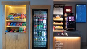 A vending machine with snacks and beverages, a coffee machine, and a menu board. - Holiday Inn Express Birmingham Airport NEC by IHG (Birmingham)