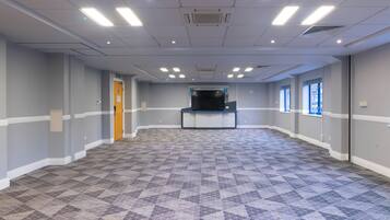 A spacious room with a patterned floor, a reception desk, and a door.