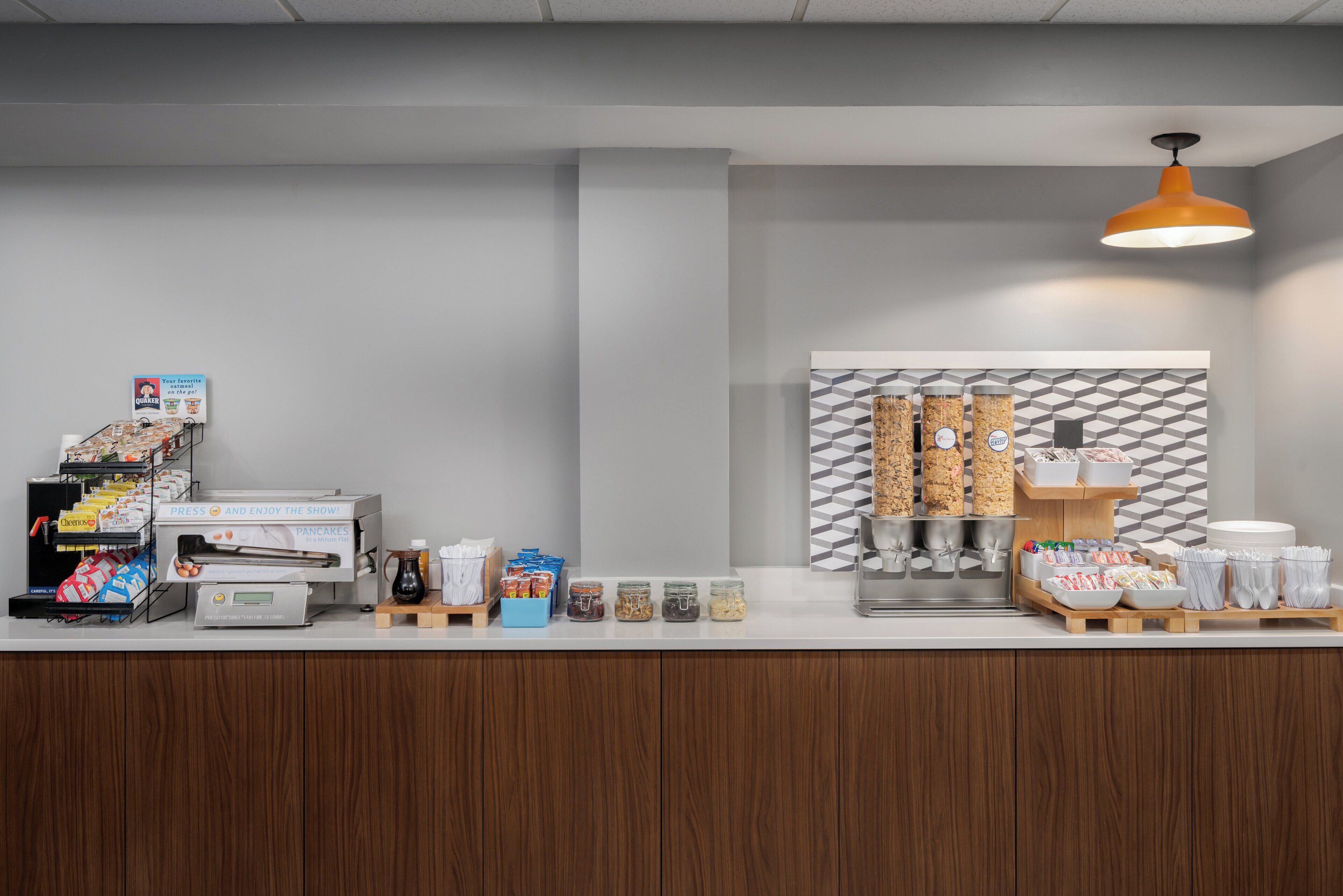 A breakfast bar with a coffee machine, cereal, and condiments.