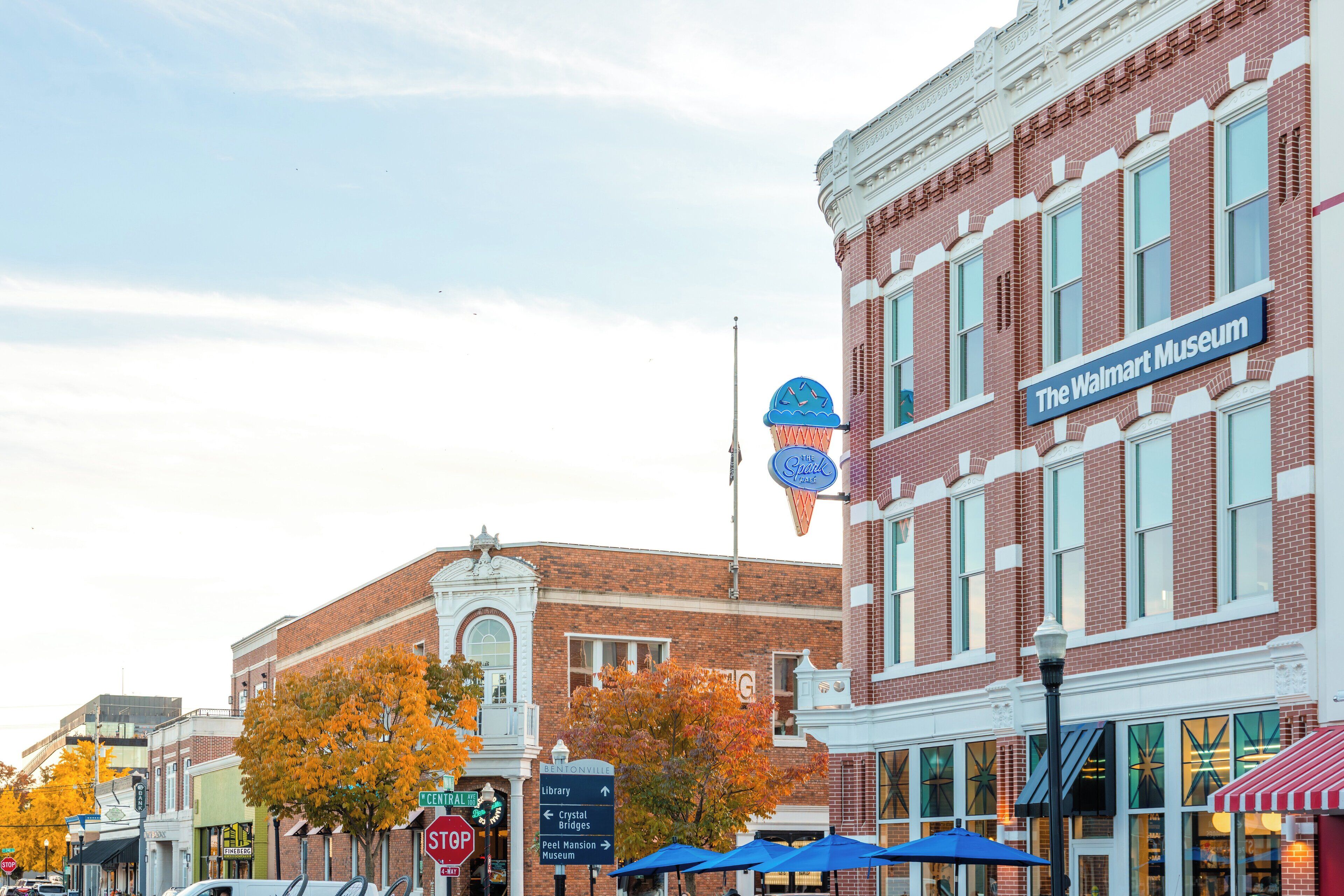 A street view with a building labeled "The Walmart Museum" and a stop sign.