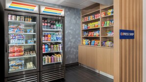 Un espace de restauration en libre-service, équipé de distributeurs de boissons réfrigérées et d’étagères remplies de collations et de boissons.