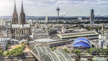 Panoramic city views feature a cathedral, modern tower, and blue-domed stadium.
