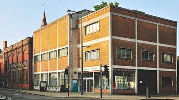 A multi-story brick building with large windows and a sign for the Derby Museum and Art Gallery.