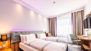 A hotel room with two beds, a desk, a chair, a TV, and a lamp. - Premier Inn Essen City Limbecker Platz (Essen)