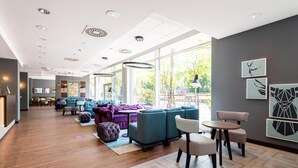 A modern hotel lobby with a seating area, large windows, and a visible reception desk. - Premier Inn Essen City Limbecker Platz (Essen)