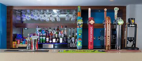 Zona de bar con diversas botellas y grifos.