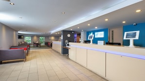 En hotellobby med en receptionsdisk, en sittgrupp och utsikt över omgivningarna.