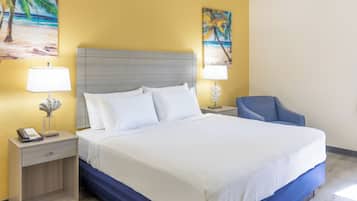 A hotel room with a bed, two bedside tables, a lamp, and a chair.