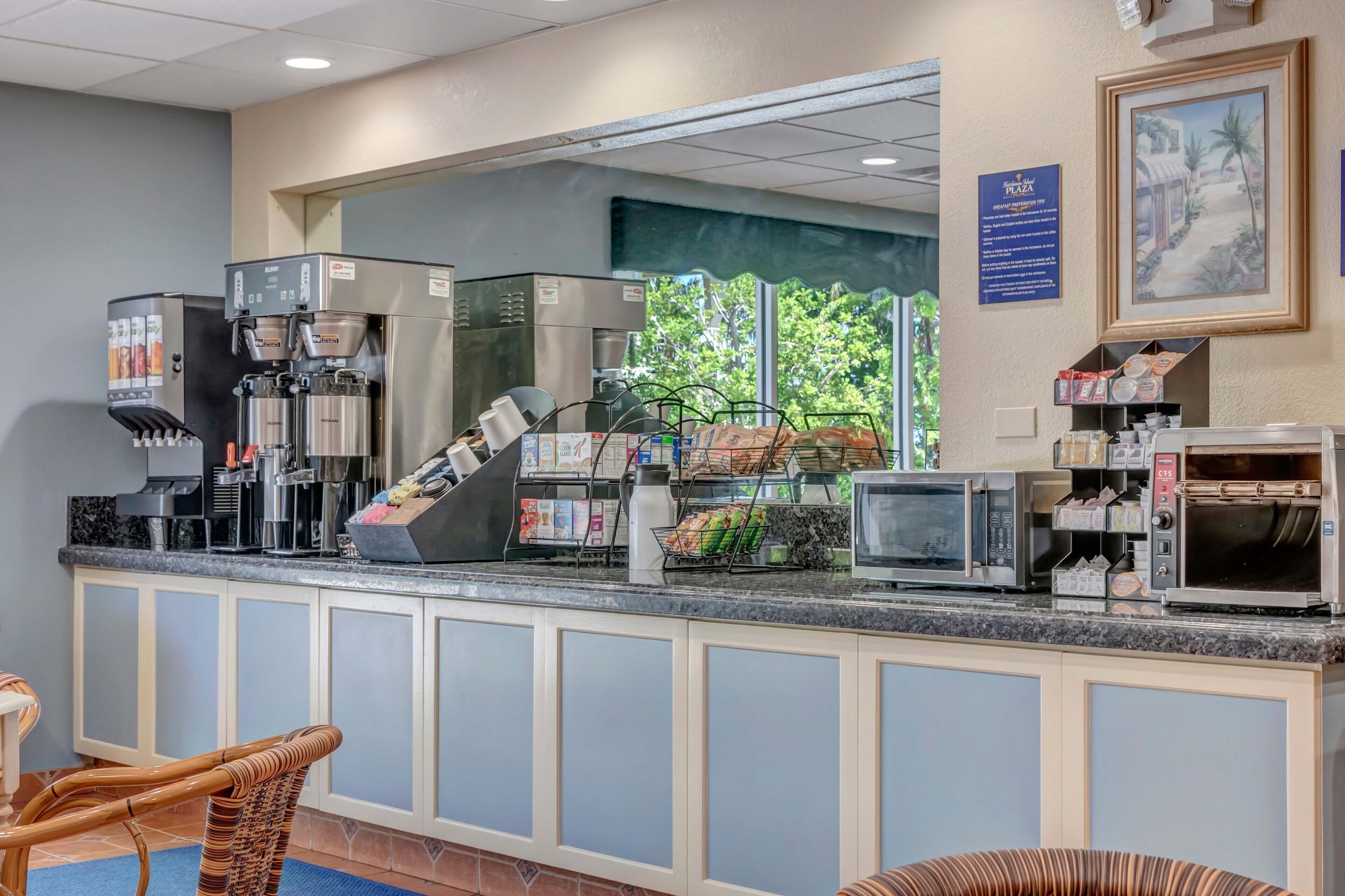 A hotel reception area with a coffee machine, microwave, and a display of snacks.