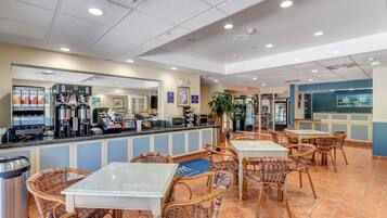 A restaurant with a counter, seating area, and various appliances.