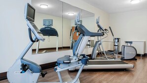 Un gimnasio con equipo de ejercicio, incluyendo cintas de correr y una máquina elíptica.