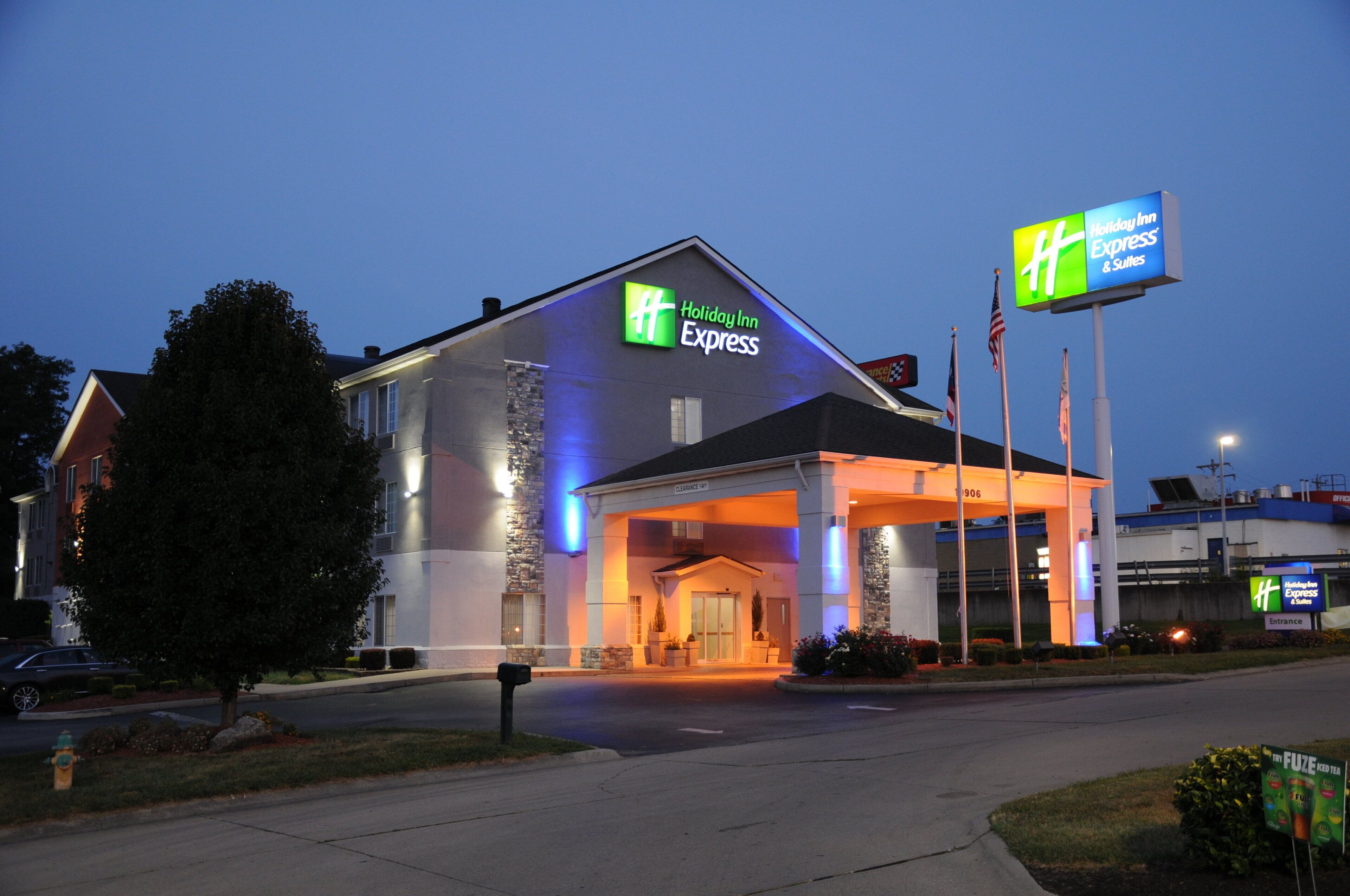 A Holiday Inn Express building with a clear entrance, a stone facade, and a sign indicating the entrance.