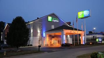 A Holiday Inn Express building with a clear entrance, a stone facade, and a sign indicating the entrance.