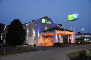 A Holiday Inn Express building with a clear entrance, a stone facade, and a sign indicating the entrance.