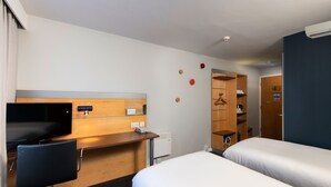 A hotel room with a bed, a desk with a chair, a television, and a wardrobe. - Holiday Inn Express Leeds City Centre by IHG (Leeds)