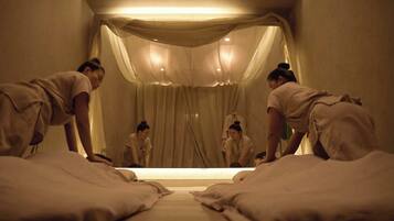 Cozy retreat with a central bed and two smaller beds, surrounded by sheer curtains and a canopy for a sense of privacy.