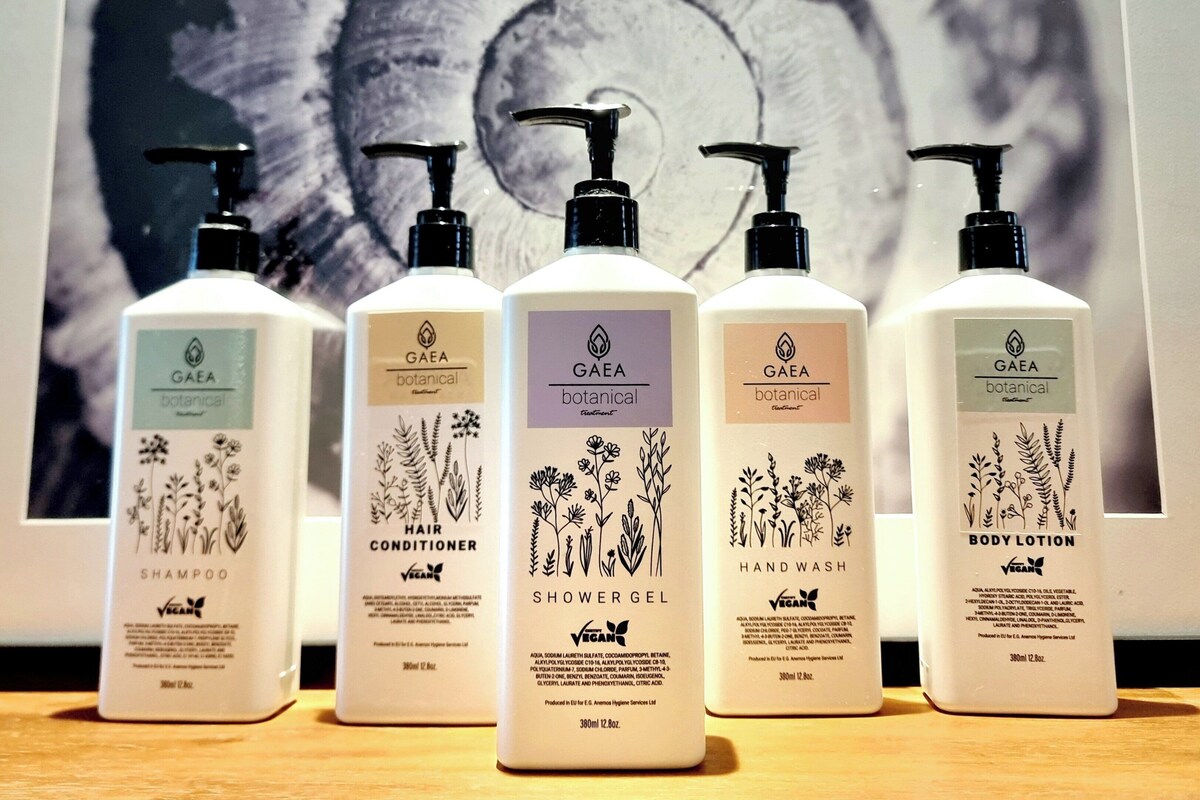 Cinq flacons de revitalisant capillaire, de gel douche, de savon pour les mains et de lotion pour le corps, tous de la marque Gaea et à base d’ingrédients naturels.