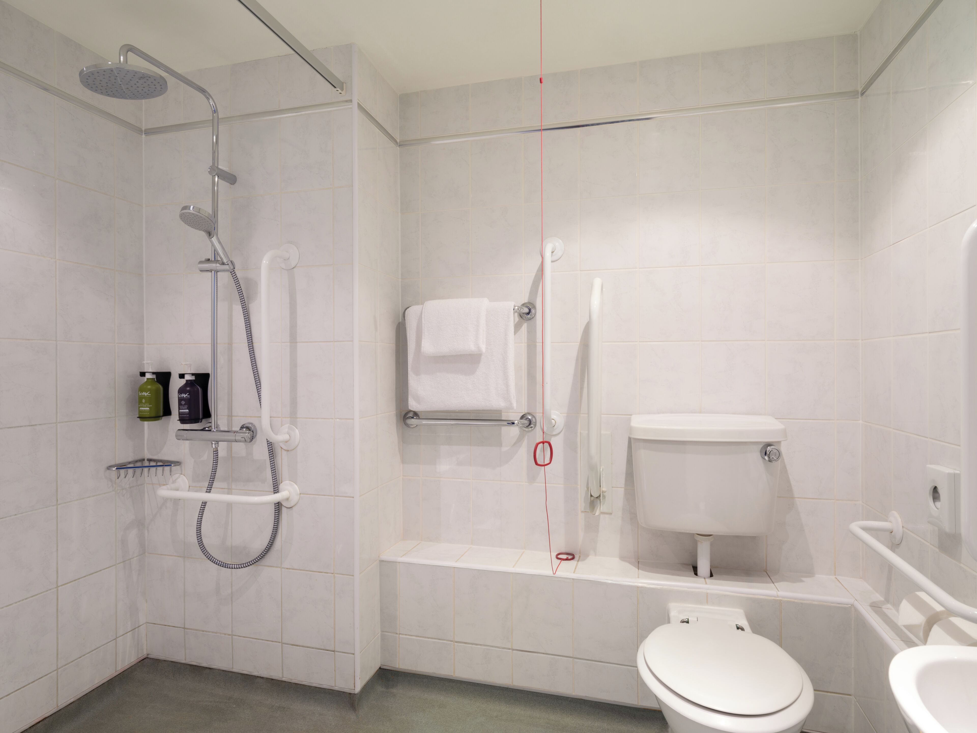 Une salle de bain moderne équipée d’une douche, de toilettes et d’un lavabo.