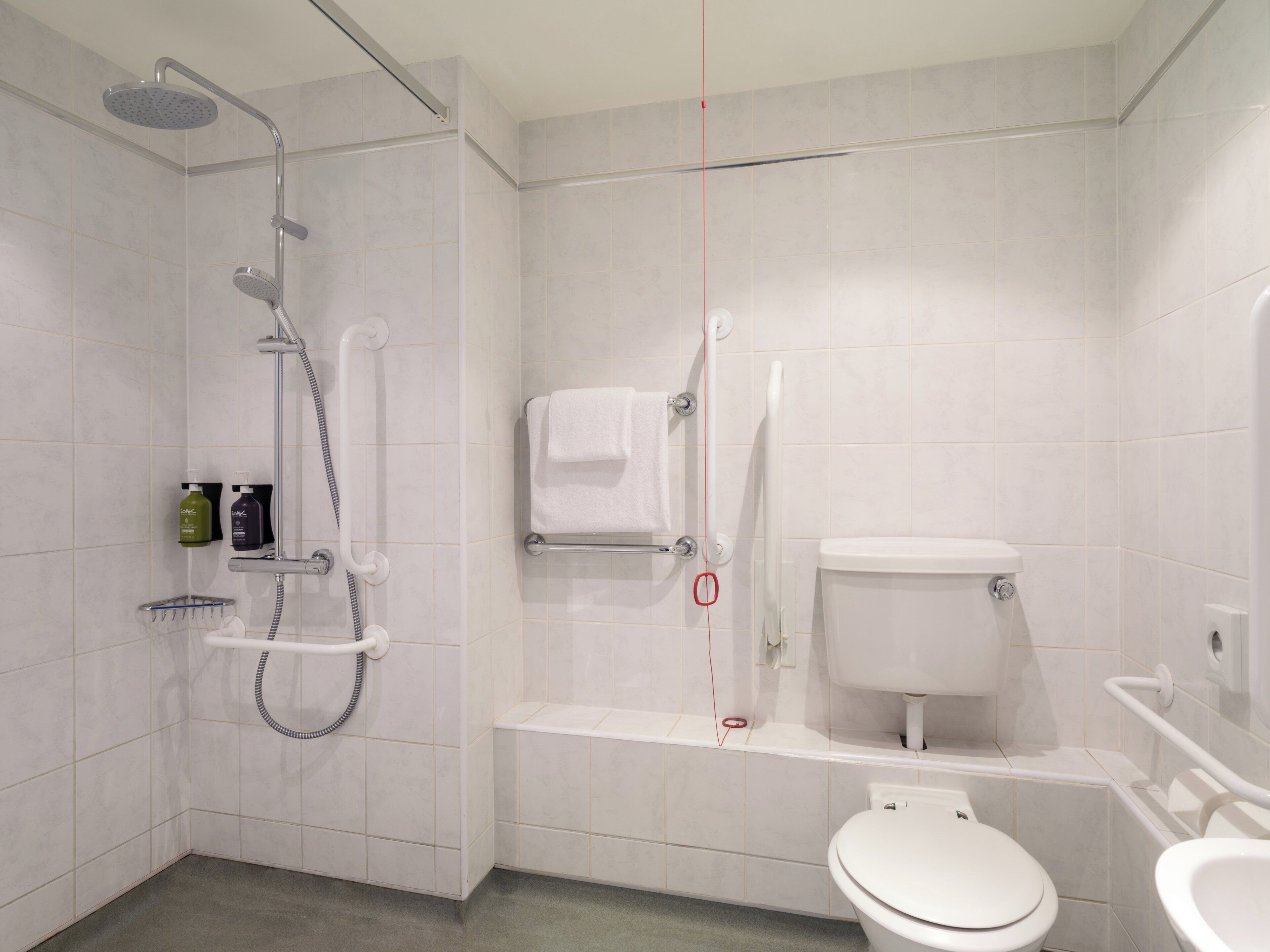 A modern bathroom with a shower, toilet, and sink.