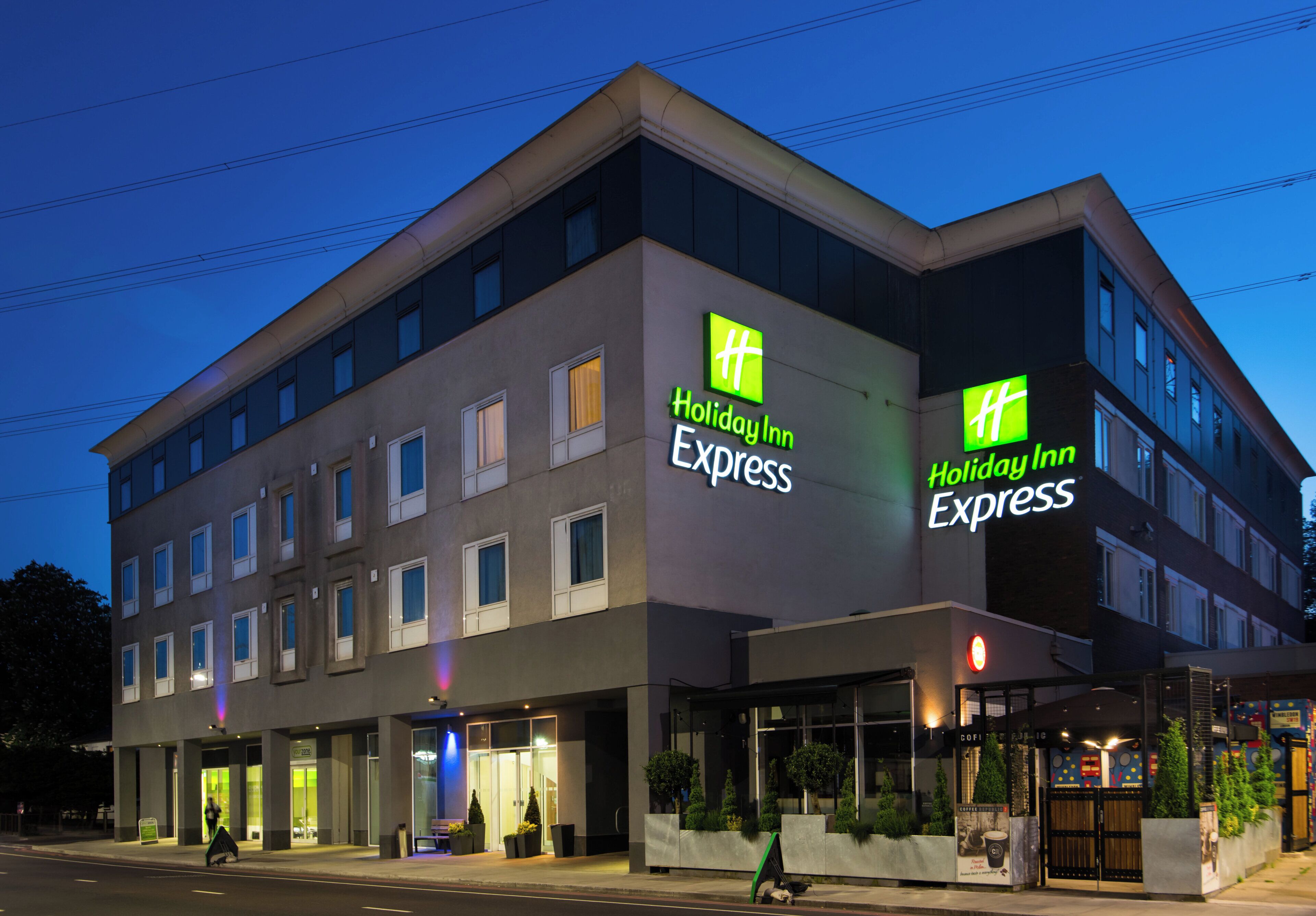 A Holiday Inn Express hotel with a modern facade, multiple windows, and a visible entrance.