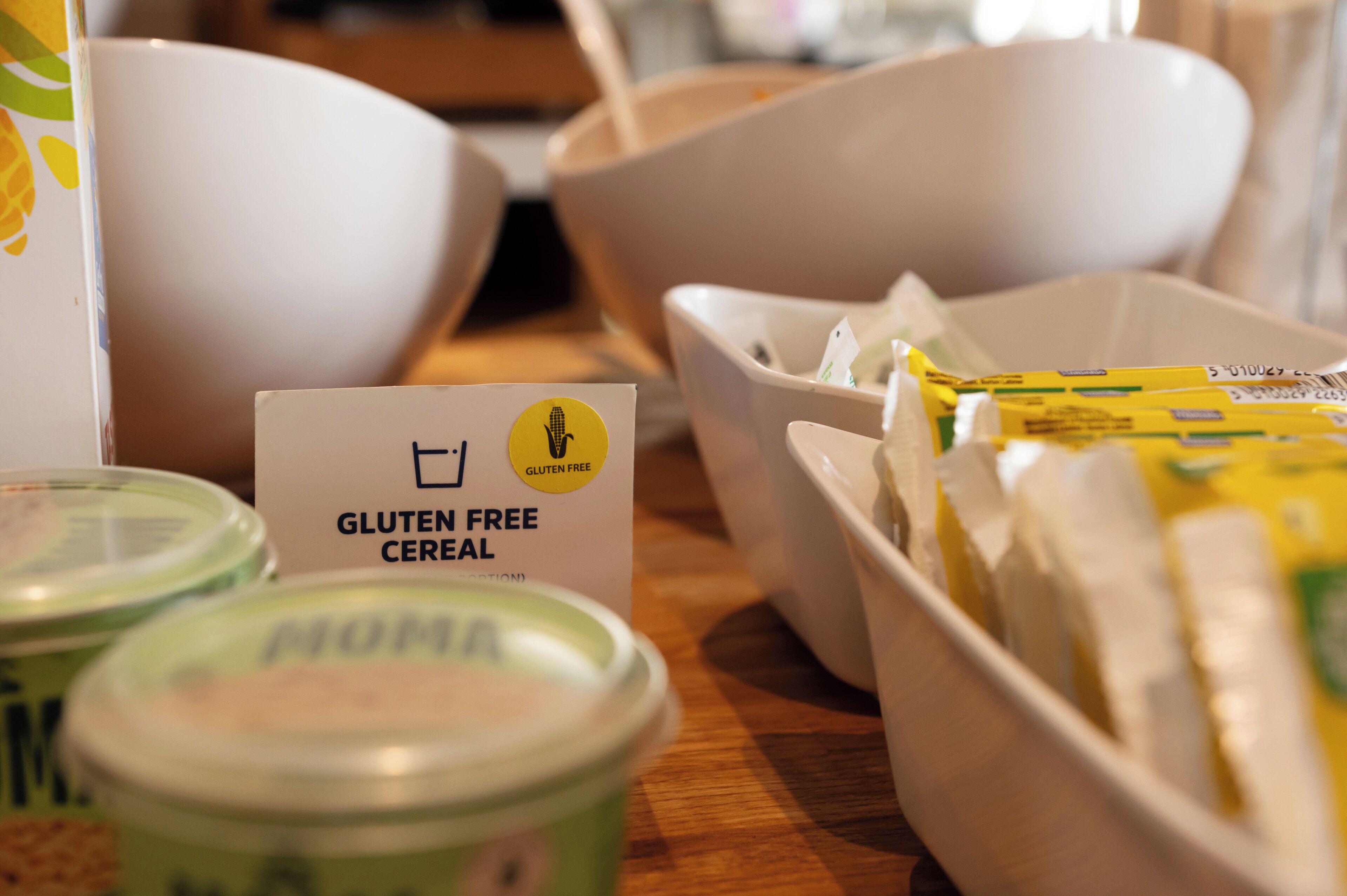 A table with various food items including gluten-free cereal, a bowl, and containers.