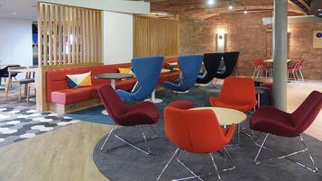 A modern lounge area with sofas, chairs, and tables.