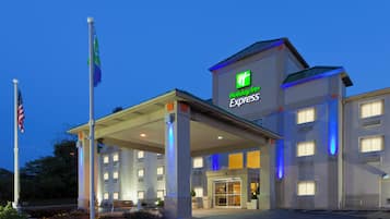 A Holiday Inn Express hotel with a covered entrance, flagpole, and illuminated signage.