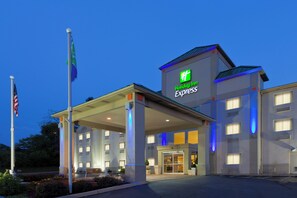 A Holiday Inn Express hotel with a covered entrance, flagpole, and illuminated signage.