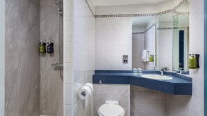 A modern bathroom with a shower, toilet, and sink.