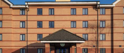 A multi-story hotel with a prominent entrance and a sign above the door.