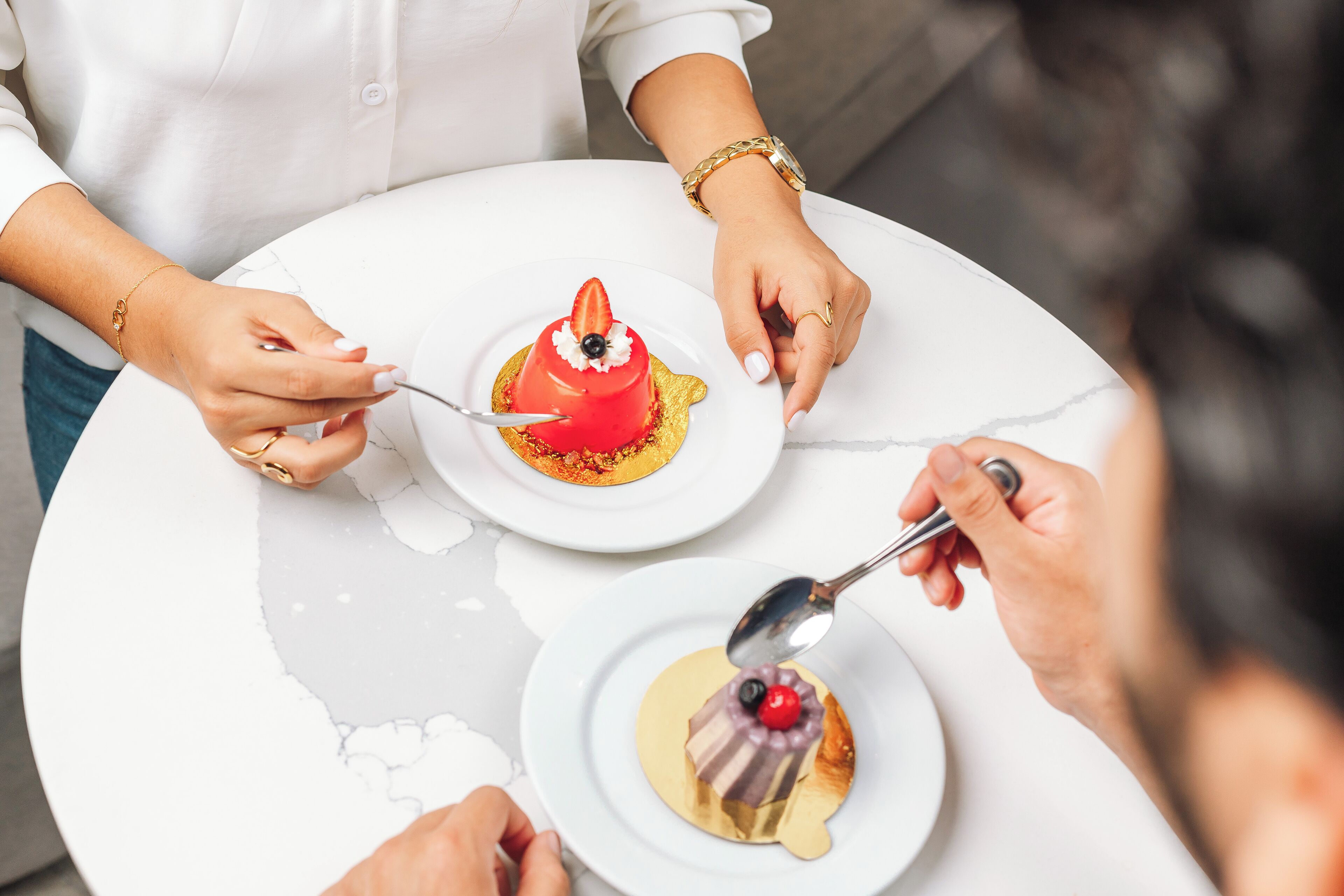 A round table with two white plates, each with a dessert.