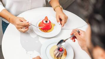A round table with two white plates, each with a dessert.