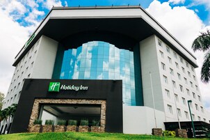 Un hotel Holiday Inn con un diseño moderno, que destaca por su amplia fachada de vidrio y una entrada enmarcada en piedra.