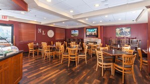 A restaurant with wooden tables and chairs, a clock, and a fireplace. - The Niobrara Lodge (Valentine)